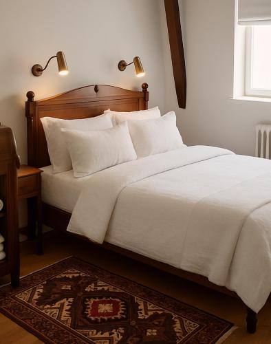 a bed with white sheets and pillows in a bedroom at Appartement dans Château exceptionnel PISCINE -GOLF -TENNIS in Les Forges