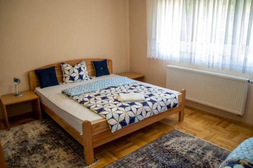 a bedroom with a bed with blue pillows and a window at Apartment Stella in Bihać