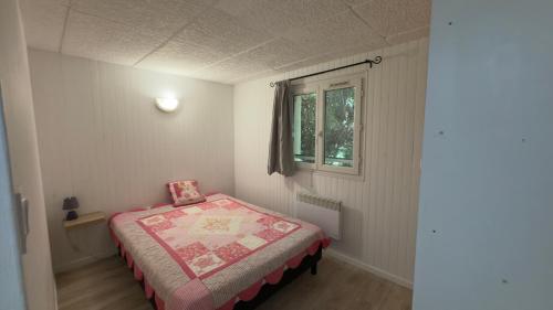 une petite chambre avec un lit et une fenêtre dans l'établissement L’appartement du Micocoulier, à Salon-de-Provence
