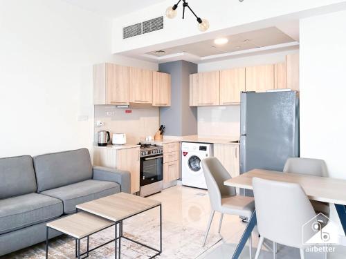 a kitchen and living room with a couch and a table at City-View Studio in AG Tower l Pool & Gym Access in Dubai
