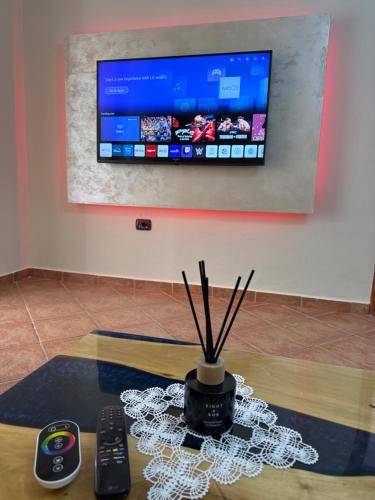ein Tisch mit Fernbedienungen und einem Fernseher an der Wand in der Unterkunft Casa del Mare in Durrës