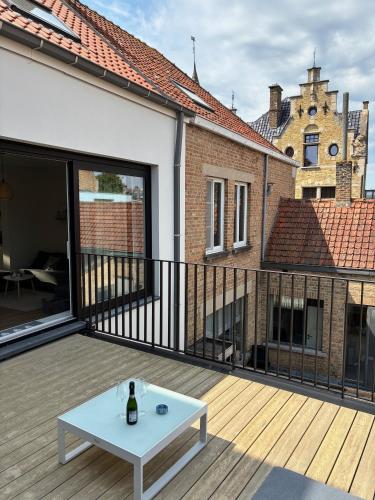 a deck with a white coffee table on a balcony at Pand 43 in Diksmuide