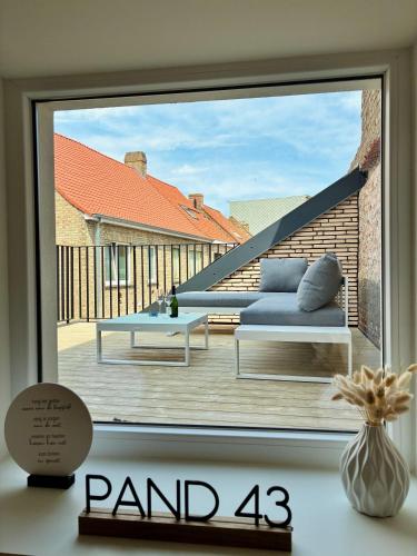 a window with a view of a balcony with a couch at Pand 43 in Diksmuide