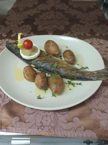 a plate of fish and potatoes on a table at Luna Hotel Serra da Estrela in Covilhã