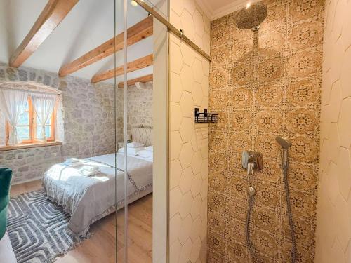 a bedroom with a shower and a bed in a room at NEW! Holiday Home Retro Stone House in Živogošće