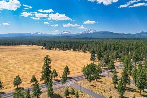 an aerial view of a road with a field and mountains at Juniper & Pine, a Lodge-Style Cabin in Sisters, OR in Sisters