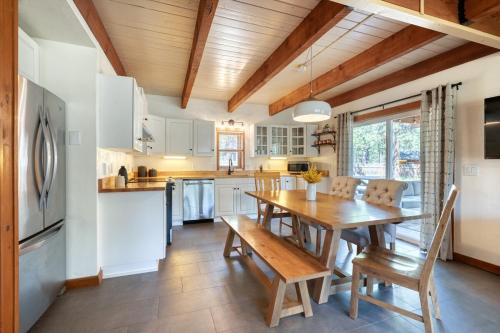 a kitchen with a wooden table and a dining room at Juniper & Pine, a Lodge-Style Cabin in Sisters, OR in Sisters