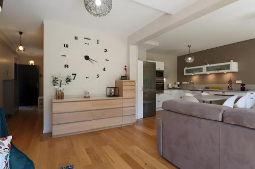 a living room with a couch and a clock on the wall at D5 - Résidence La Montille in Mont-Dore
