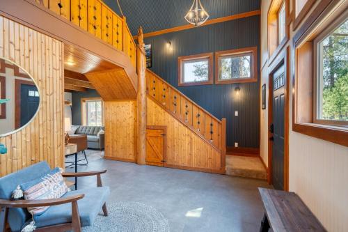 a living room with a wooden staircase in a house at Juniper & Pine, a Lodge-Style Cabin in Sisters, OR in Sisters