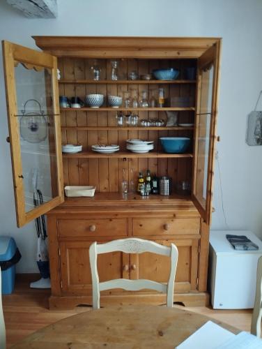 a wooden cabinet with a chair in a room at Appartement d'Artiste in Cotignac