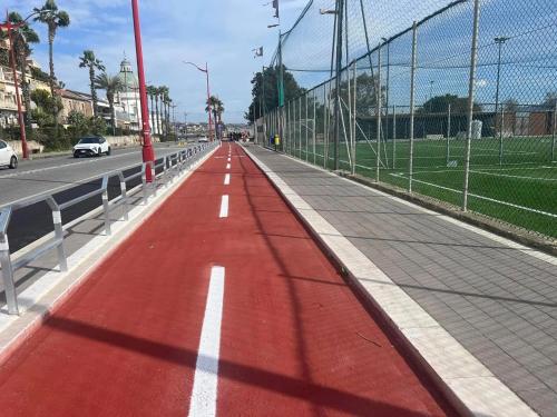 a red road with a fence on the side of a road at Vista sullo Stretto in Messina