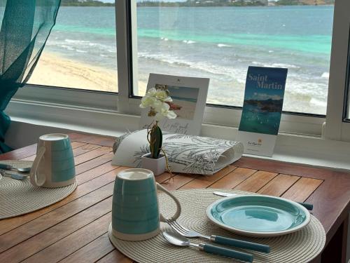 Baie NettleにあるCharmant studio sur la plage des Caraibesの窓から海の景色を望むテーブル