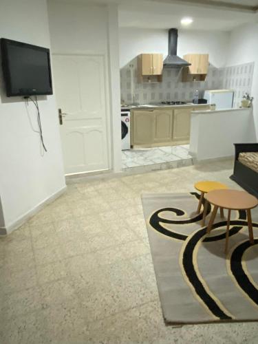 Una sala de estar con una mesa y una cocina. en Jouri, en Beni Dinhet