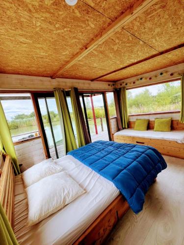 - un lit au milieu d'une chambre avec fenêtres dans l'établissement Camping Chambord, à Mont-près-Chambord