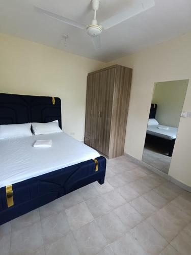 a bedroom with a large bed and a bathroom at Empire BnB in Ukunda
