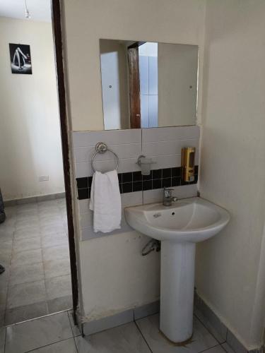 a bathroom with a sink and a mirror at Empire BnB in Ukunda