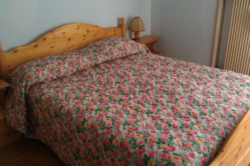 a bed with a green and red blanket on it at Casa 33 in Predazzo