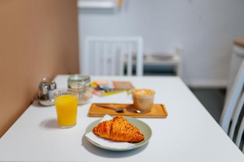 a table with a plate of food and orange juice at Kis-Duna Lak in Esztergom