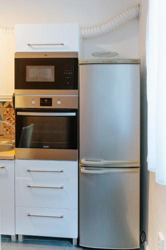 a kitchen with a stainless steel refrigerator and a microwave at Kis-Duna Lak in Esztergom