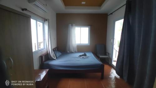 a bedroom with a bed with a dog laying on it at Green moonVillage in Ban Nok