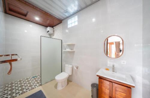 a bathroom with a toilet and a sink and a mirror at Anta Villa Lembongan in Nusa Lembongan