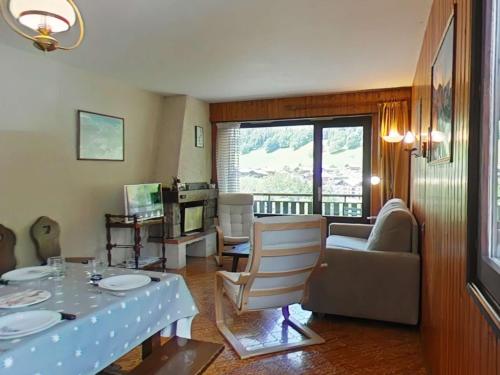 un salon avec une table et des chaises et une fenêtre dans l'établissement Appartement au pied des pistes, 4 couchages, Le Grand-Bornand - FR-1-241-202, au Grand-Bornand
