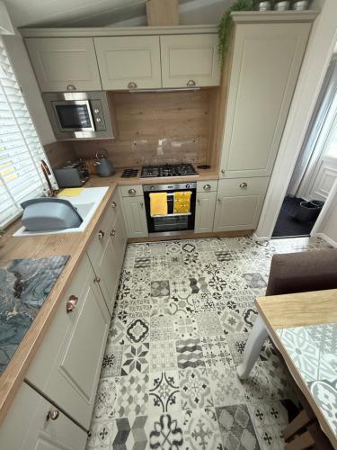 a kitchen with a sink and a stove top oven at Harbour View Hideaway in Newbiggin-by-the-Sea
