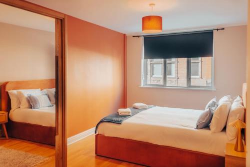 マンチェスターにあるCentral Manchester Gem with Stylish 2BR Retreat and Free Carparkのベッドと鏡のある小さな寝室