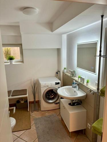 a bathroom with a washing machine and a sink at LüttelHome, moderne Ferienwohnung im Grünen mit Highspeed-Glasfaser in Brüggen