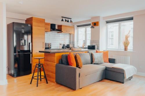 a living room with a couch and a kitchen at Central Manchester Gem with Stylish 2BR Retreat and Free Carpark in Manchester