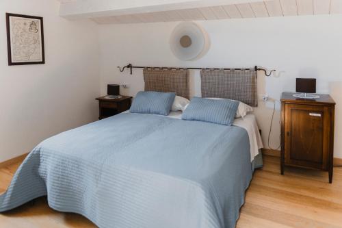 a bedroom with a blue bed with two night stands at Borgo delle Fonti in Acquaviva Collecroce