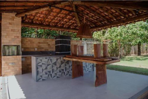een buitenkeuken met een tafel onder een pergola bij Guarajuba Summer Flat in Guarajuba