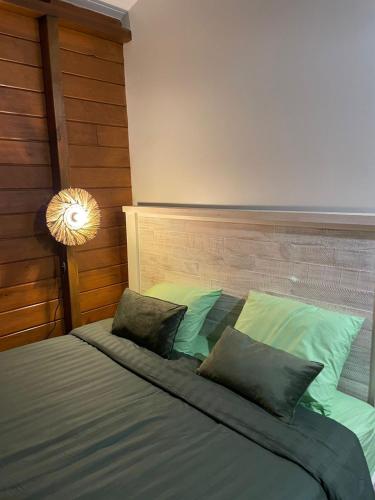 a bedroom with a bed with two pillows at Bienvenue au cocon de Moreau in Goyave