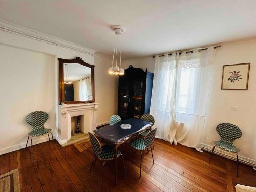 une salle à manger avec une table, des chaises et un miroir dans l'établissement Le Charmant Jaurès - Centre-ville, à Reims