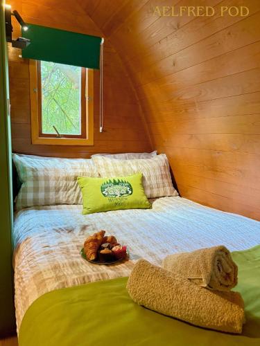 a bed in a room with some food on it at West Stow Pods in Bury St Edmunds in West Stow