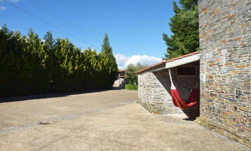 a brick building with a red hammock on the side of it at Quinta da Boa Ventura in Bragança