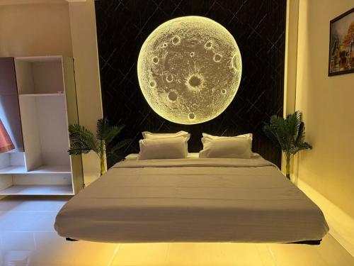 a bedroom with a bed with a large moon overhead at TriNest Garden Villa in Nagpur