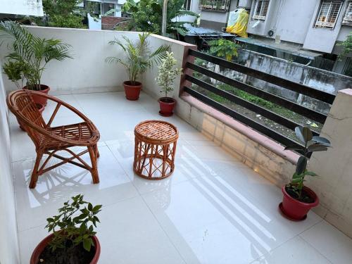 a balcony with chairs and potted plants on a building at TriNest Garden Villa in Nagpur