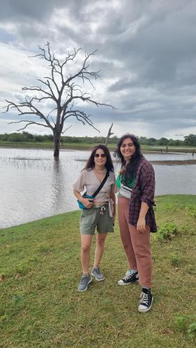 two women standing next to a body of water at Traget safari home stay in Udawalawe