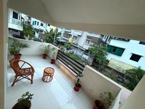 an apartment balcony with a bench and potted plants at TriNest Garden Villa in Nagpur