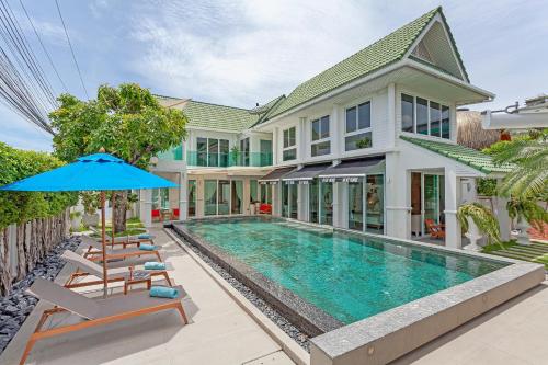 an exterior view of a house with a swimming pool at Hi At Home Villa 5 in Nong Prue