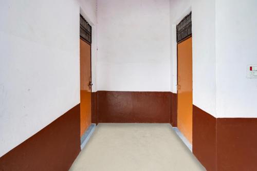 ein leerer Flur mit zwei Türen in einem Gebäude in der Unterkunft Hotel O Siddhi Vinayak Farms in Hāthras