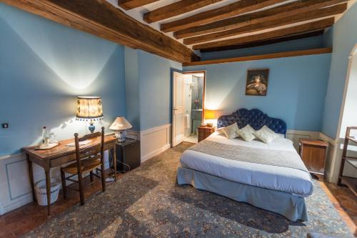 a bedroom with a bed and a desk in a room at Le Relais Cicero in La Flèche