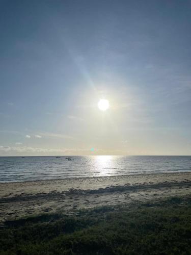 a beach with the sun rising over the ocean at Pousada Quinta das Flores in Icapuí