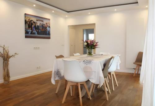 une salle à manger blanche avec une table et des chaises dans l'établissement Superbe appartement 5pièces 2 SDB 2WC standing, à Créteil