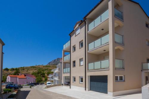 an apartment building with a hill in the background at Casa Moderna - New Spacious Apartments in Lokva Rogoznica