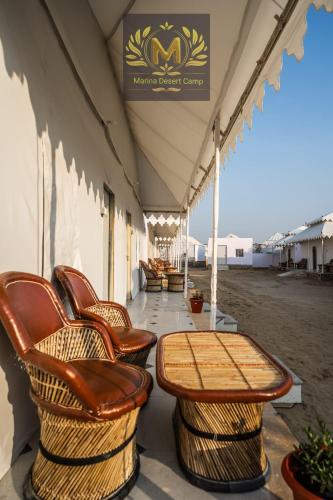 a tent with chairs and a table on a patio at Marina Dessert Camp in Sām