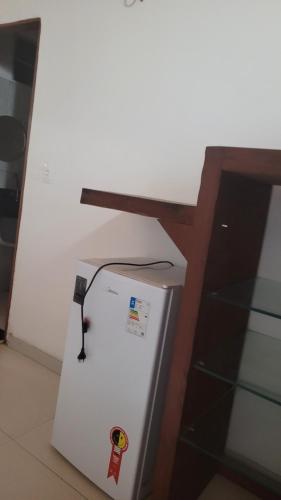 a refrigerator with a table on top of it at Flechimar Suítes in Trairi