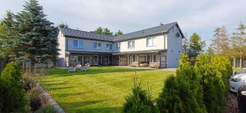 a large white house with a yard at Apartamenty Nadmorskie lofty in Gąski
