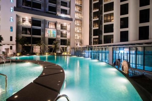 a large swimming pool in a building at night at Panoramic Seaview KK City The Shore at Mixma Suites in Kota Kinabalu